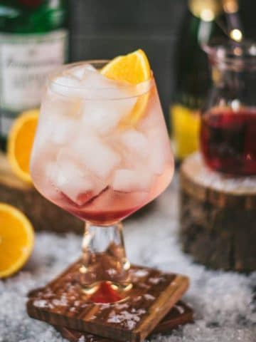 Stunning cranberry gin spritz, garnished with a slice of orange. Refreshing and festive!