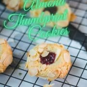 Delectable raspberry almond thumbprint cookies placed on a cooling rack.