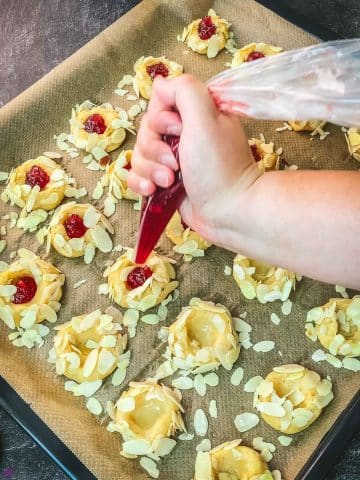 Fill the cookies indentations with raspberry jam.