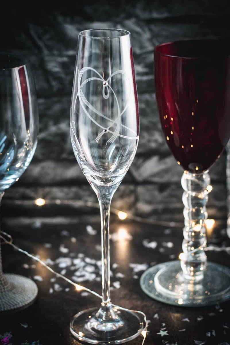 A variety of gorgeous wine, sparkling wine, and collins glasses placed in dark room.