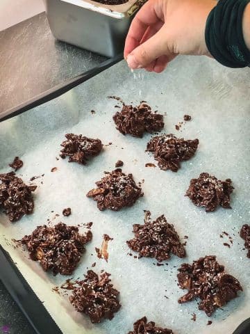 Sprinkle the cornflake clusters immediately with desiccated coconut.