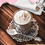 Medieval glass mug, filled with delicious strawberry white hot chocolate and topped with strawberry-flavored whipped cream.