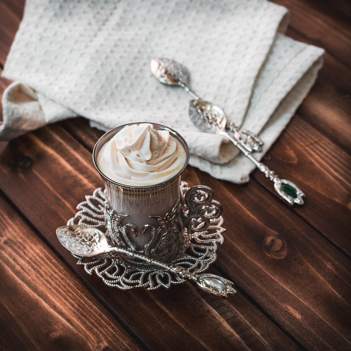 Medieval glass mug, filled with delicious strawberry white hot chocolate and topped with strawberry-flavored whipped cream.
