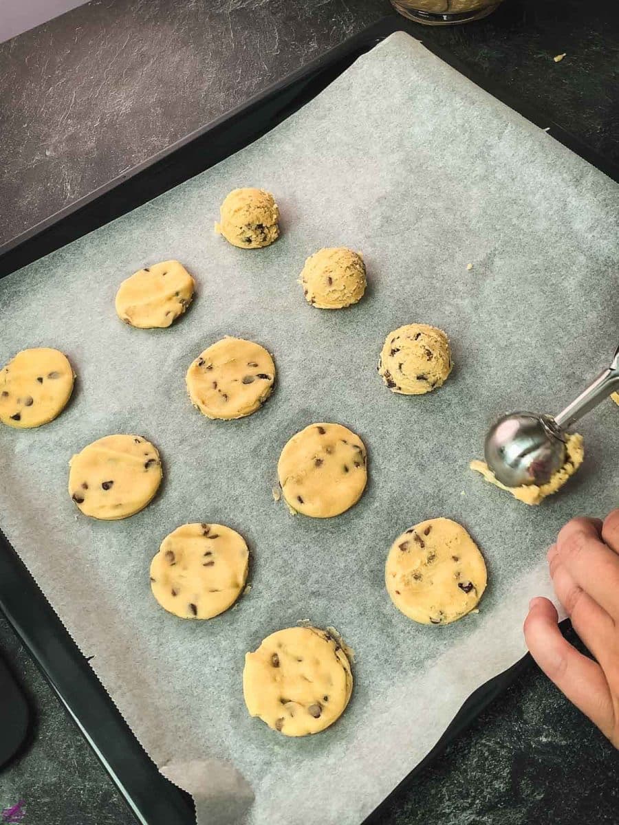 Scoop out the cookie dough., placing the dough balls on a baking sheet lined with parchment paper.