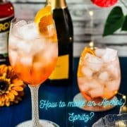 Wonderful layered Aperol Spritz! Tart and delicious! Placed on a mirror coaster on a blue wooden background.
