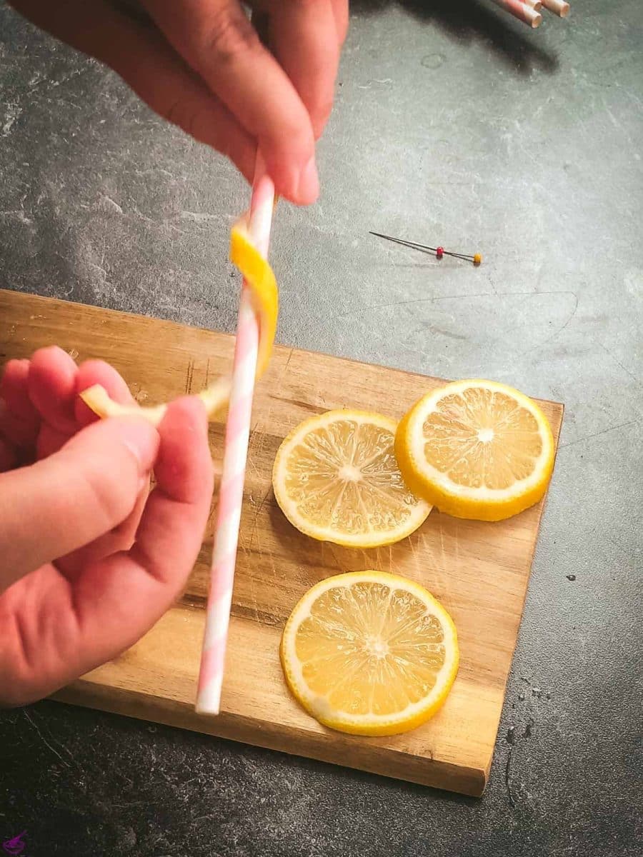 Wrap the lemon peel tightly around a paper straw.