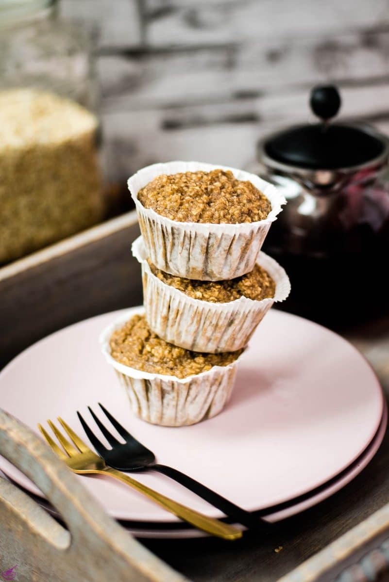 A magnificent tower of banana oatmeal muffins on a wooden tray. Behind it, delicious red tea.