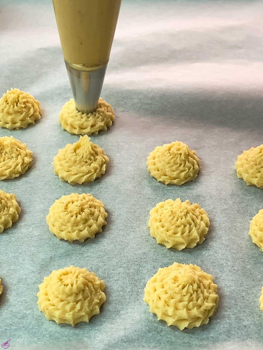 Pipe the lemon cookie dough on a baking sheet lined with parchment paper.