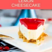 A slice of delicious Valentine's Raspberry Cheesecake placed on white plate next to a golden fork .