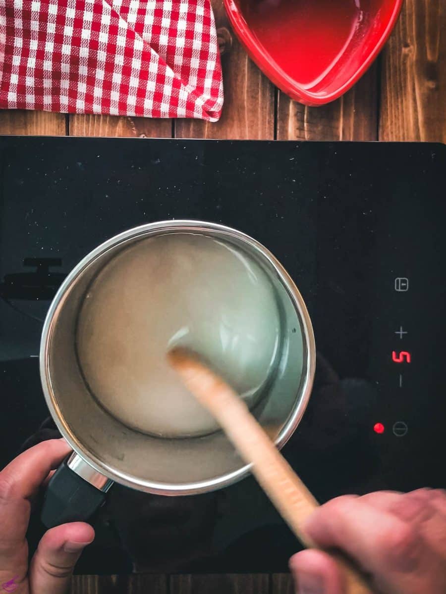 In a saucepan, stir with a wooden spoon to dissolve the sugar in the water.