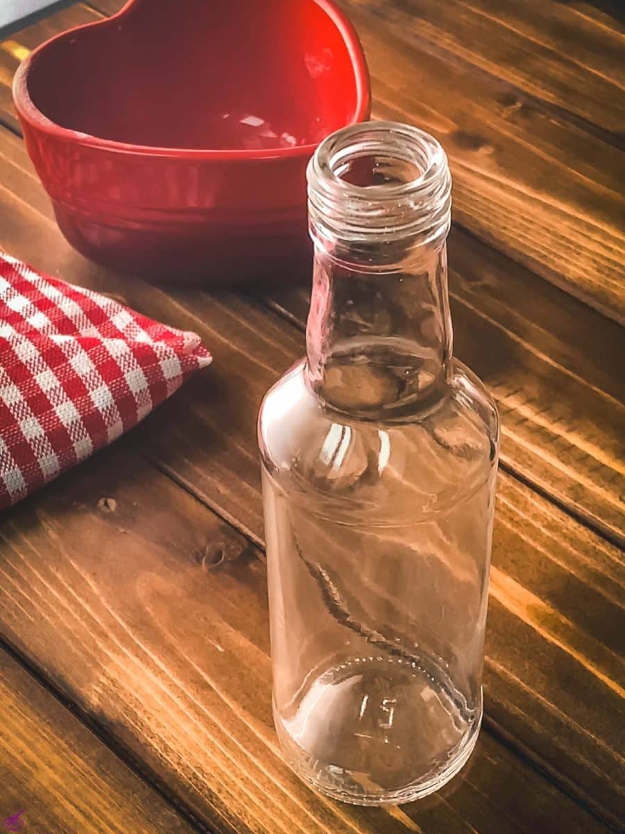 Empty preserving bottle, placed on wooden ground.