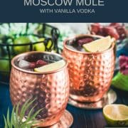 Gorgeous copper cups filled with delicious strawberry Moscow mule placed on blue wooden ground.