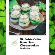 Gorgeous no bake lime cheesecakes in a jar for celebrating St. Patrick's Day! Placed on a white plate sitting on a brown wooden floor.