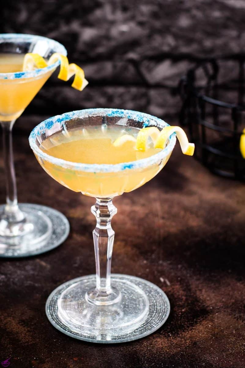 Whiskey sidecar with gorgeous lemon twist and white blue sugar rim.