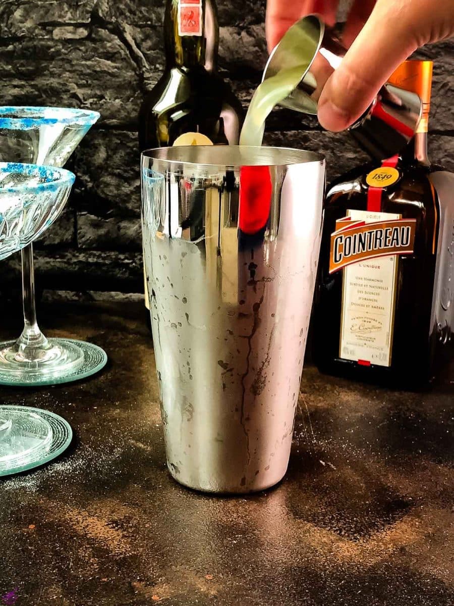 Add lemon juice to the cocktail shaker.