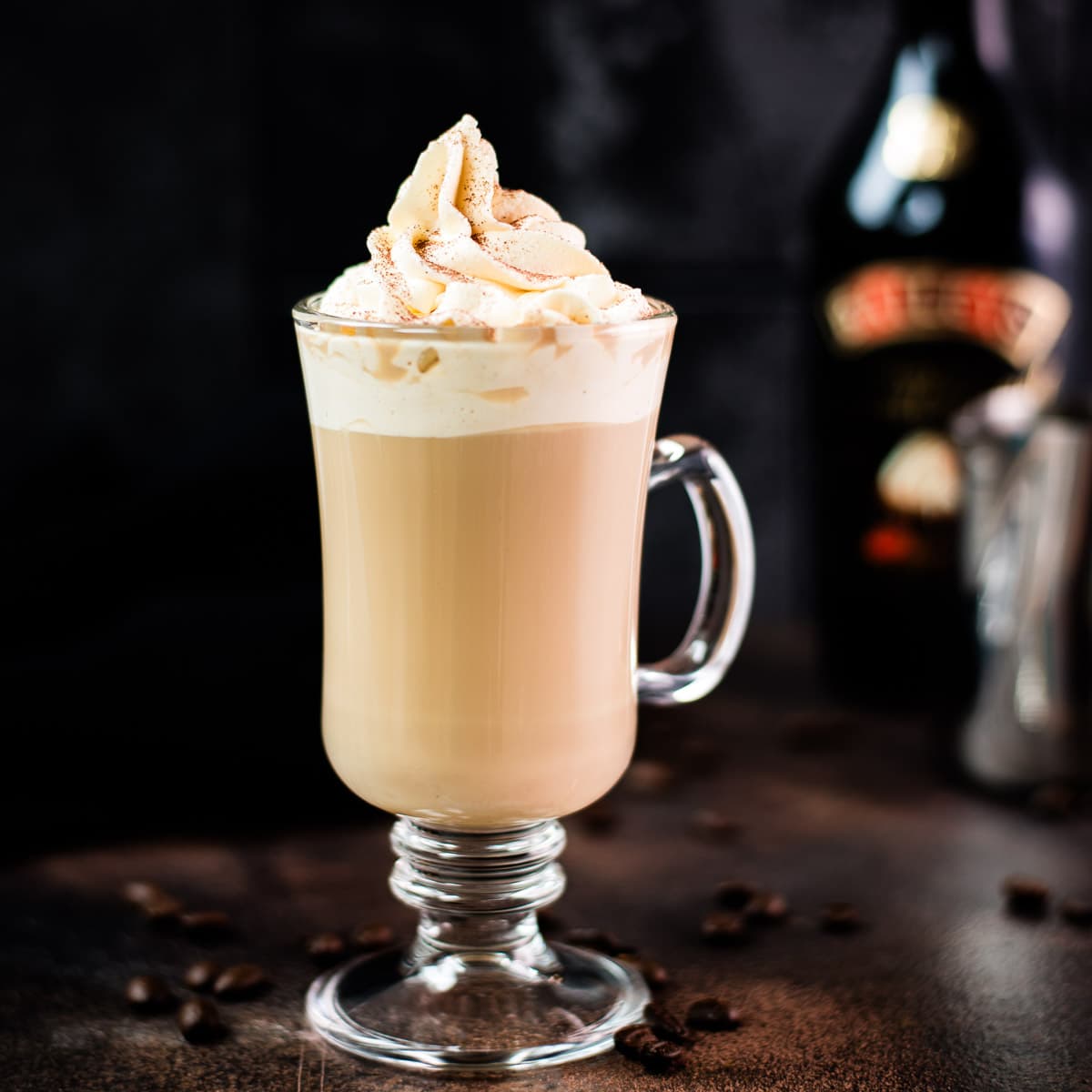 Decadent Bailey'S coffee, served in beautiful glass, placed on dark ground and topped with delicious whipped cream.