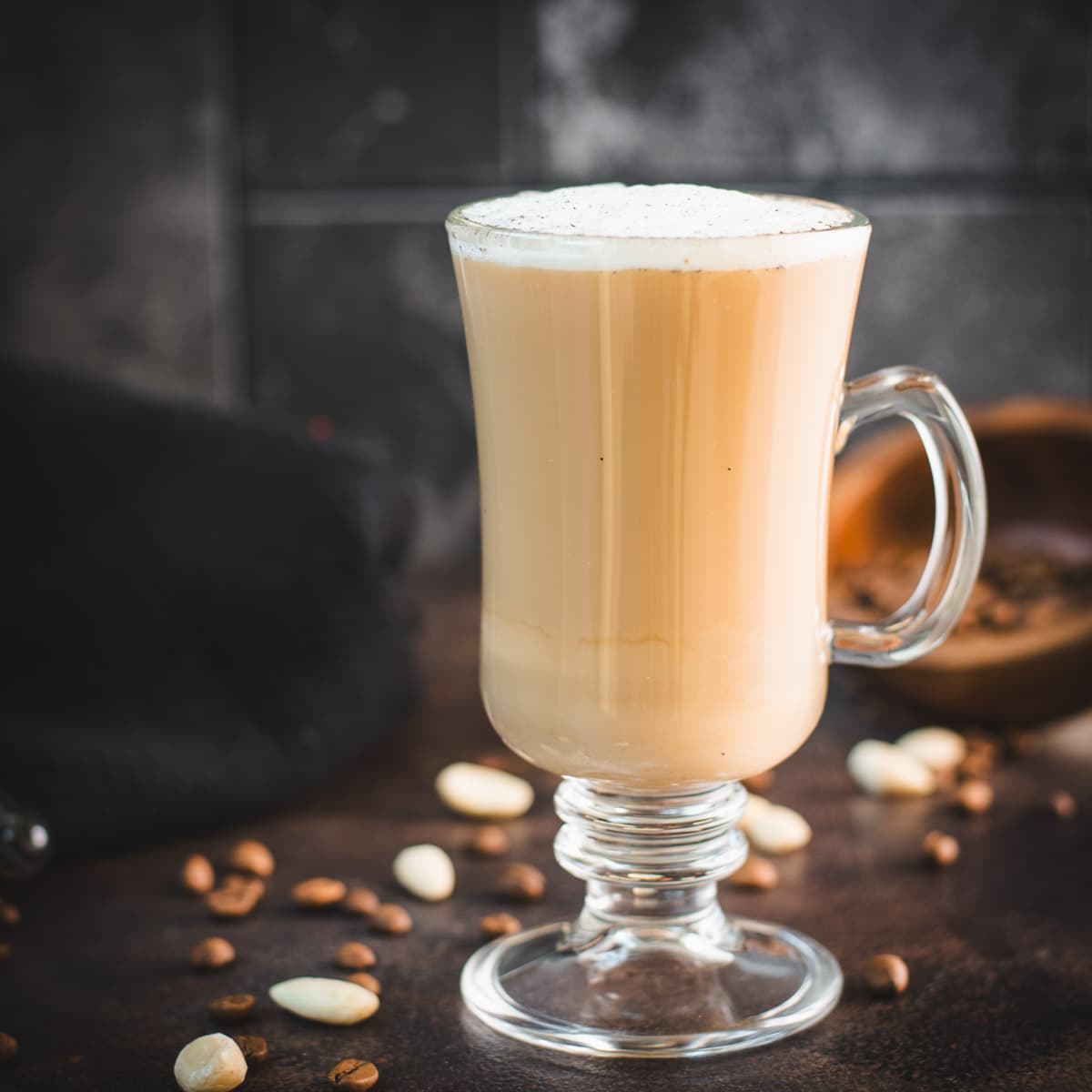 Delicious hot vanilla coffee, made with homemade almond vanilla milk, placed on dark ground.