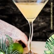 Gorgeous colored daiquiri in cocktail glass. Placed on a wooden board and dark wooden coaster.