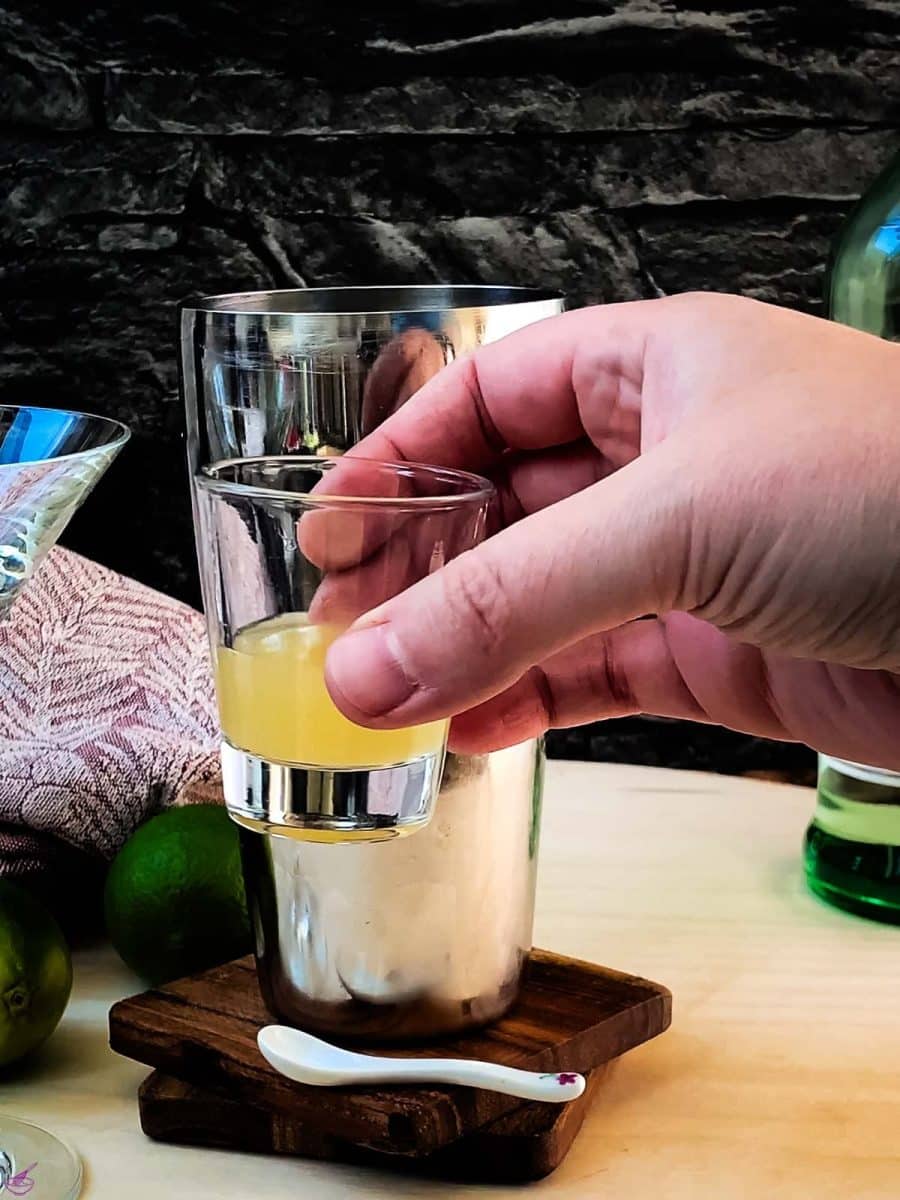 Add lime juice to the cocktail shaker.