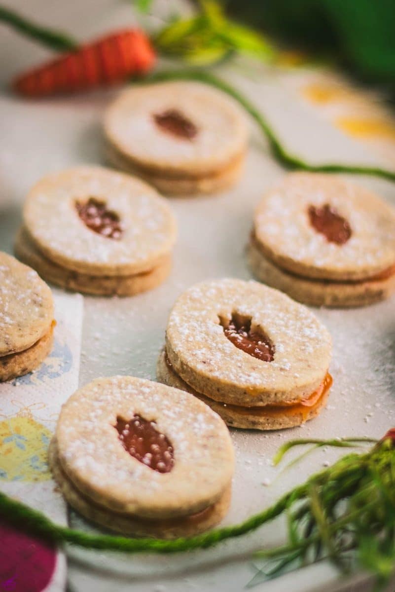 Gorgeous vegan Easter cut out cookies with apricot jam, placed on a white stone plate