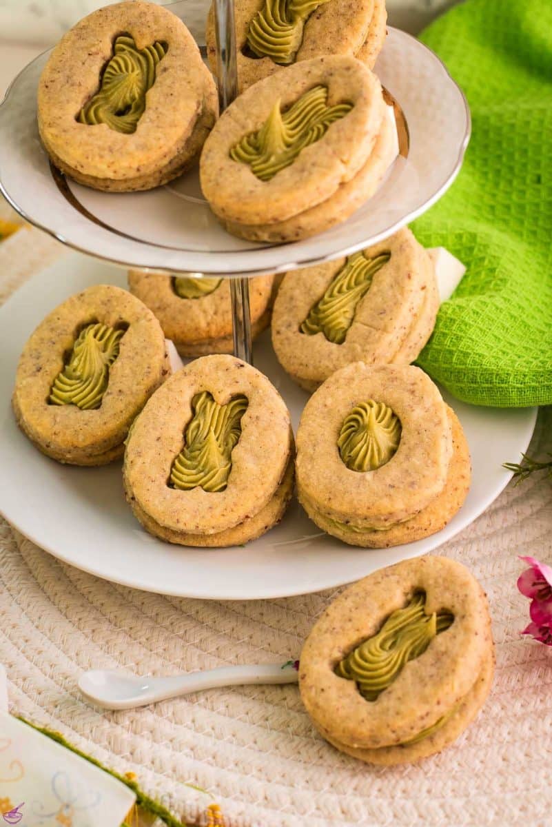 Gorgous cut out Easter cookies with pistachio ganache placed on cute tray.