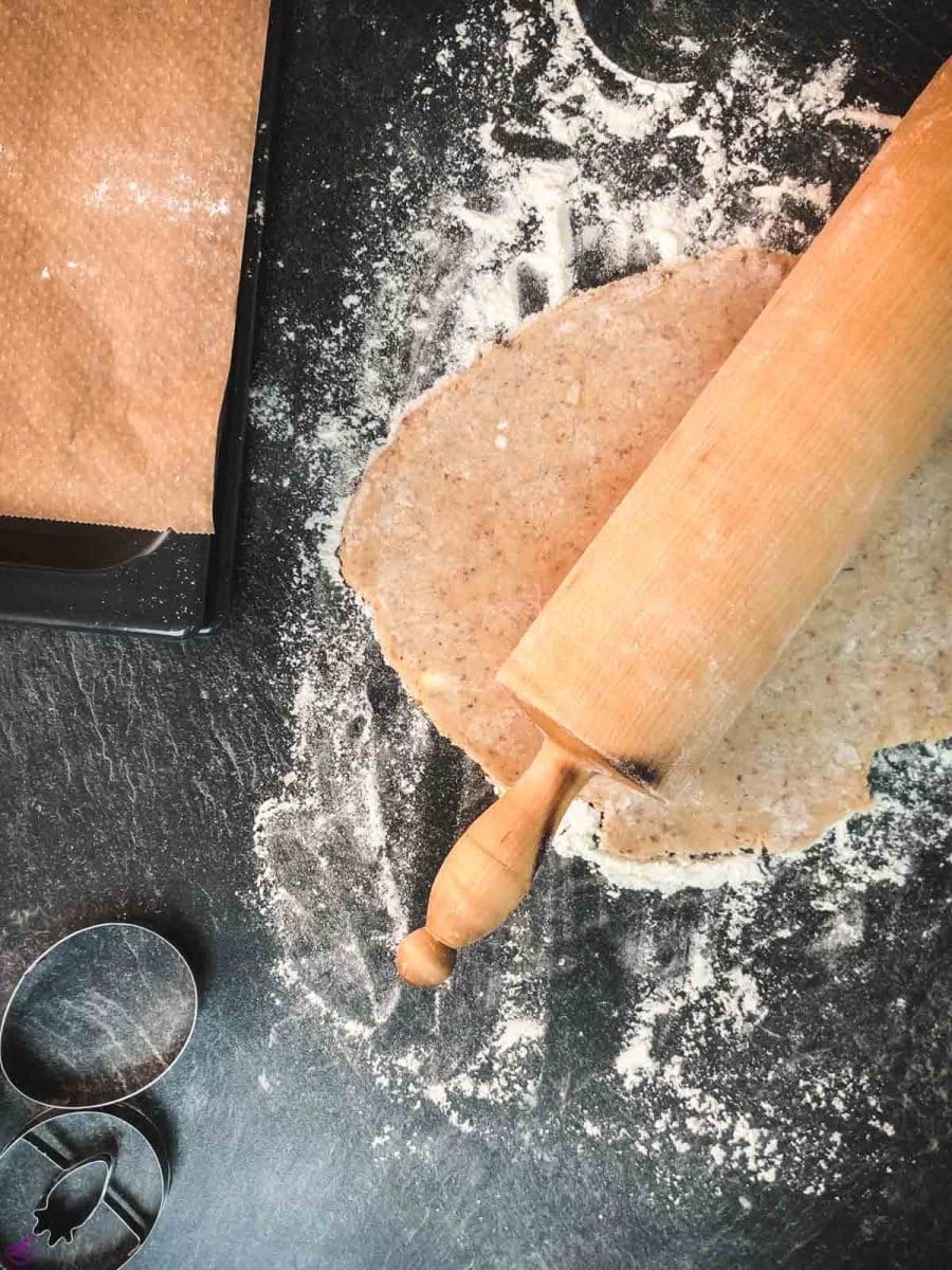 Roll out the ground almond cookie dough using a rolling pin.