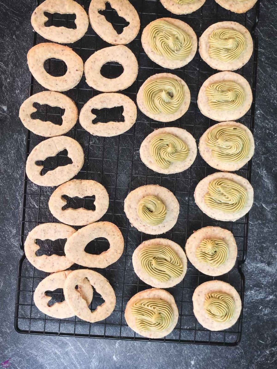 Pipe the pistachio ganache on every cut out cookie without a motif.