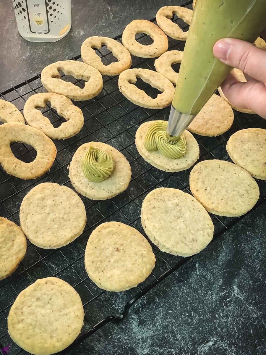 Pipe the pistachio ganache on every cut out cookie without a motif.