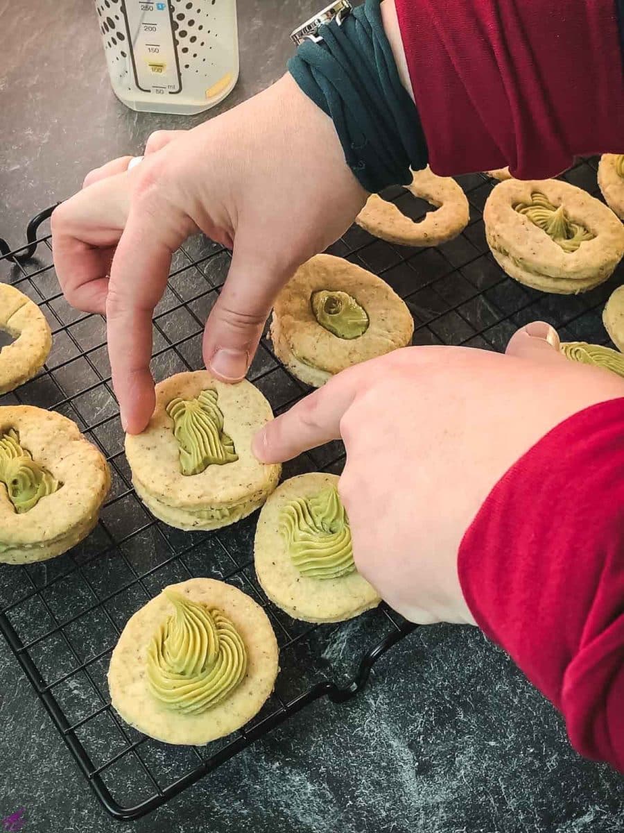 Carefully place the cut-out motif cookie on top of the pistachio ganache.