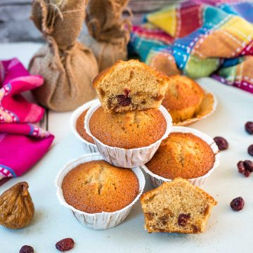 Delicious, and very easy to make, fruit cake muffins, filled with dried figs and dried cranberries. Placed on white plate.