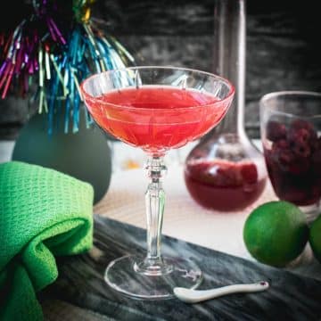 Gorgeous raspberry daiquiri with a vibrant red color placed on marble plate.