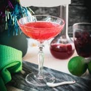 Gorgeous raspberry daiquiri with a vibrant red color placed on marble plate.