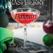 Gorgeous raspberry daiquiri with a vibrant red color placed on marble plate.