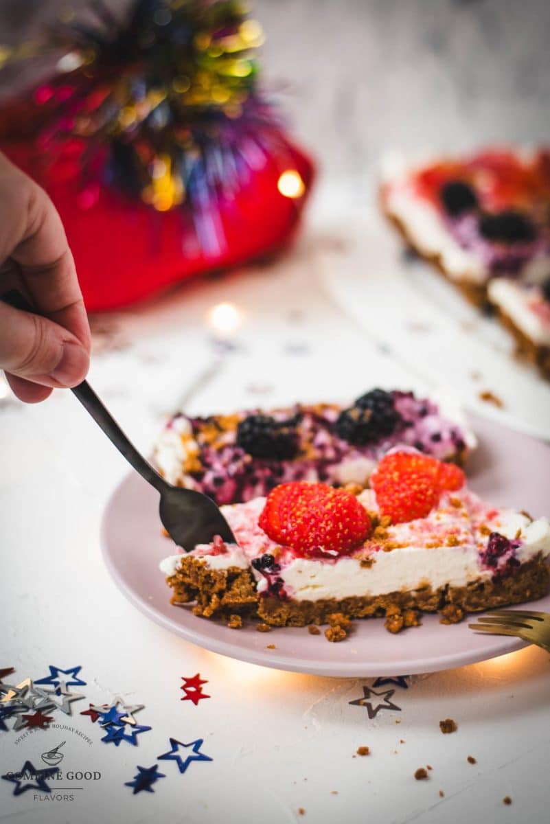 Delicious no-bake 4th of July fruit tart slices, placed on pink plate and two forks that wanna grab a bite.