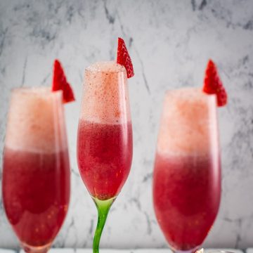 Gorgeous colored champagne flutes filled with vibrant berry mimosa.