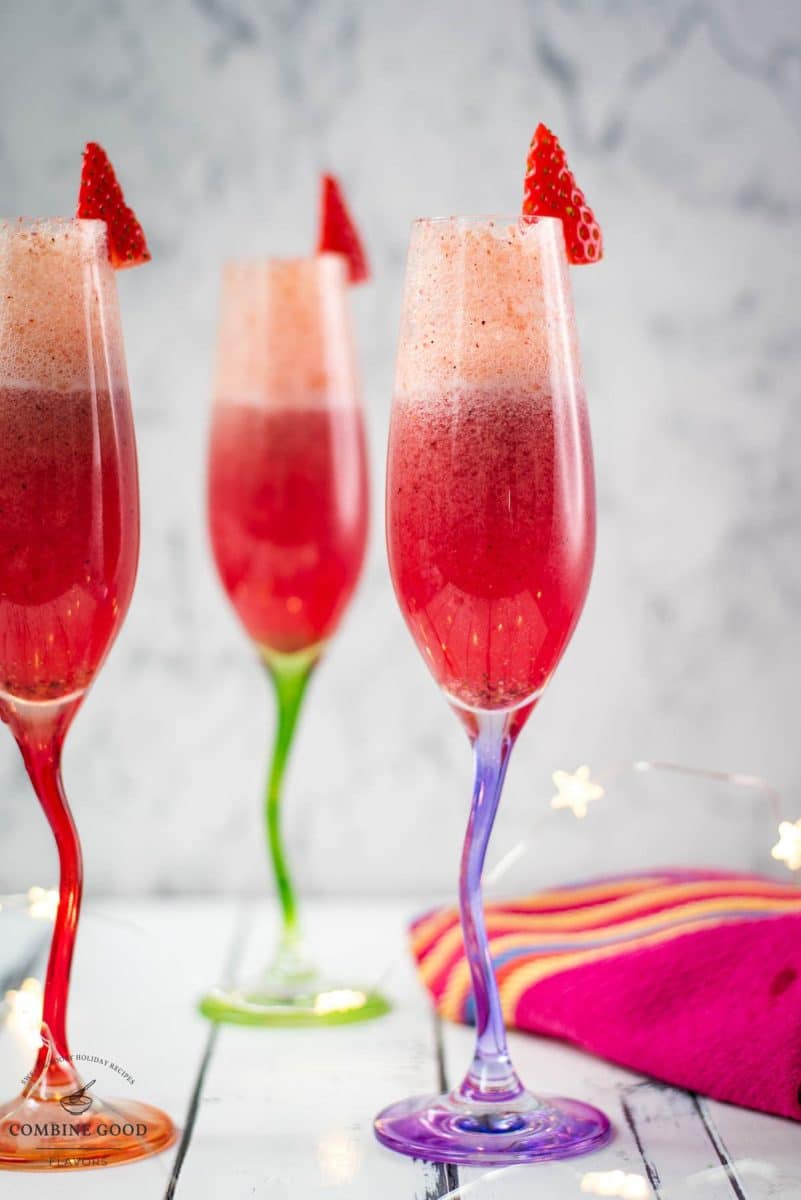 Gorgeous colored champagne flutes filled with vibrant berry mimosa.