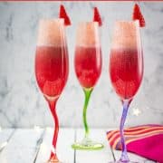 Gorgeous colored champagne flutes filled with vibrant berry mimosa.