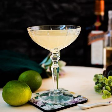 Gorgeous silky Margarita, served in cocktail glass and placed on coaster with flower pattern.