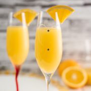 Gorgeous mimosa, garnished with orange slice in cute glass with small gems.