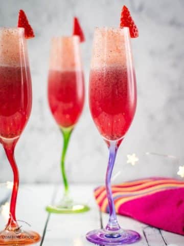 Gorgeous colored champagne flutes filled with vibrant berry mimosa.