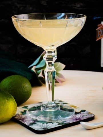 Gorgeous silky Margarita, served in cocktail glass and placed on coaster with flower pattern.