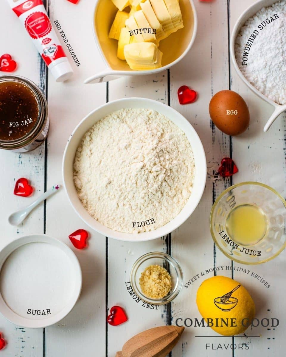 Ingredients for making heart shaped sugar cookies with fig jam and marbled glaze - flour, fig jam, butter, egg, powdered sugar, lemon juice, lemon zest, sugar and red food coloring.