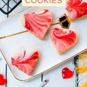 Gorgeous heart shaped sugar cookies with marbled icing, and filled with fig jam. Placed on gorgeous white golden serving plate.