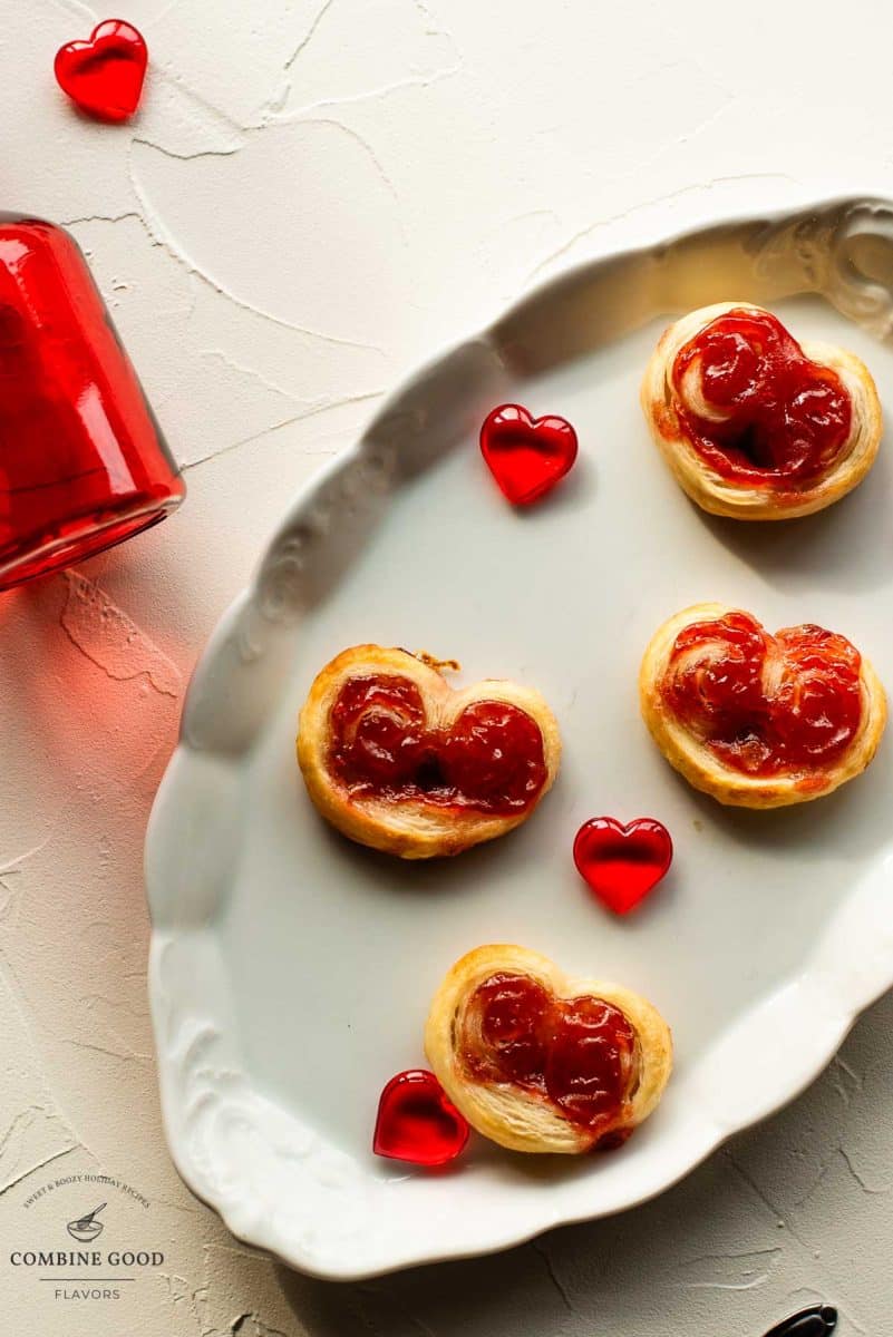 Beautiful puff pastry hearts with strawberry jam, trapped on an elegant, old serving platter. Decorated with glass hearts.