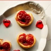 Beautiful puff pastry hearts with strawberry jam, trapped on an elegant, old serving platter. Decorated with glass hearts.