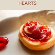 Beautiful puff pastry hearts with strawberry jam, trapped on an elegant, old serving platter. Decorated with glass hearts.