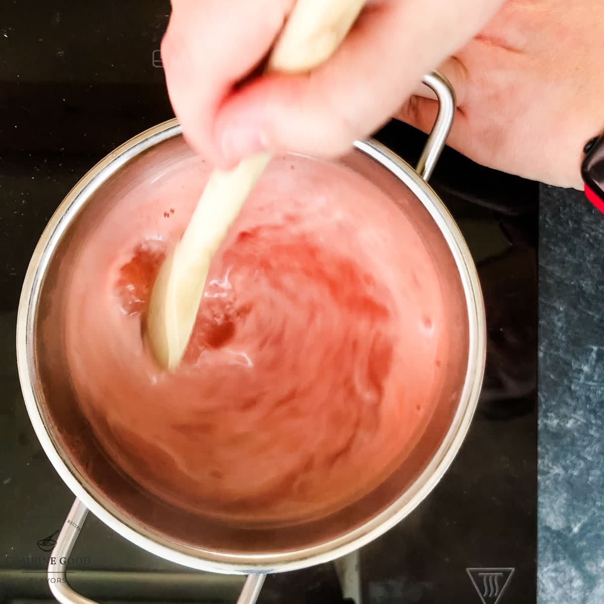 Saucepan mit melon syrup that is stirred.