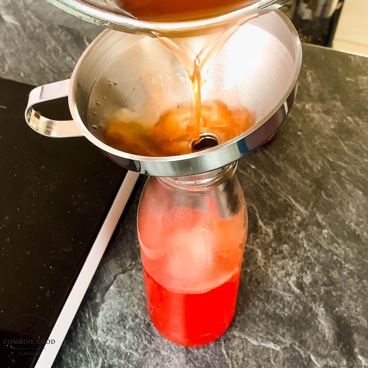 Fill the hot watermelon syrup into the preserving jar using a funnel.