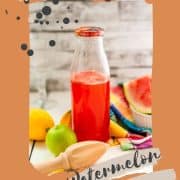 Preserving bottle filled with vibrant watermelon syrup placed on white wooden ground.