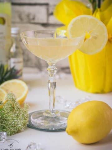 Gorgeous Limoncello Martini cocktail with elderflower syrup. Garnished with a lemon slice and placed on a mirrored coaster.